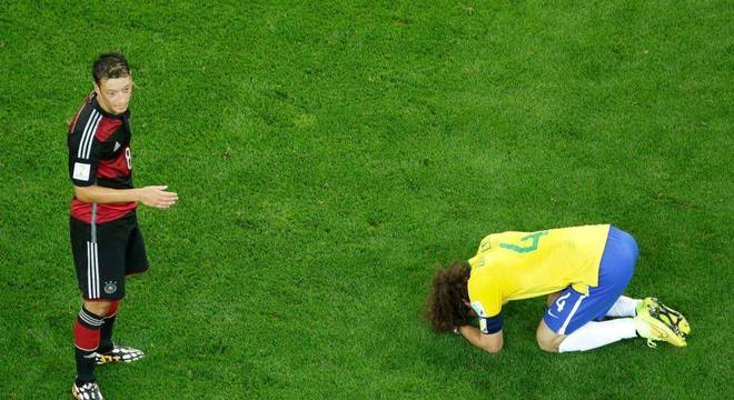 David Luiz aos pés de Ozil após o vexame no Mineirão. Retrato do fracasso