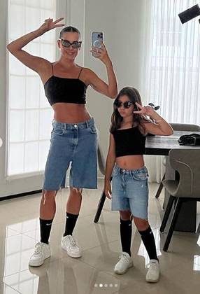 Ainda no post, mãe e filha posaram iguaizinhas, de cropped preto, bermuda jeans de cintura baixa, meia preta 3/4, tênis branco e óculos de solLEIA TAMBÉM: Body cavado, peça hit entre famosas, valoriza curvas e dá charme ousado aos looks