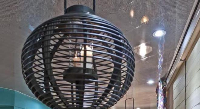 Decoração com pendentes aramados pretos acima da mesa de madeira