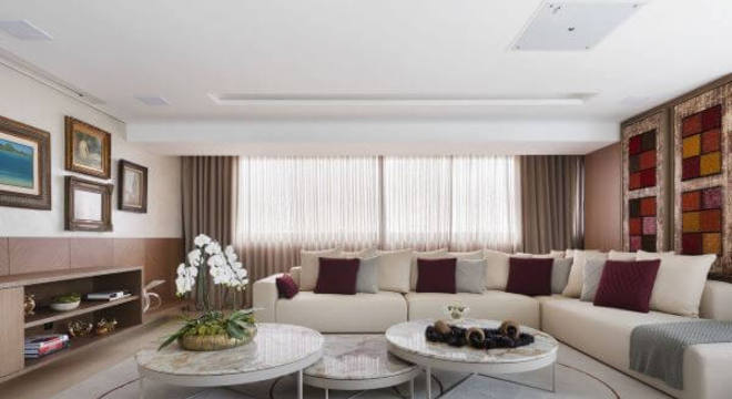 Decoração de sala de estar com cores neutras para parede e almofadas decorativas