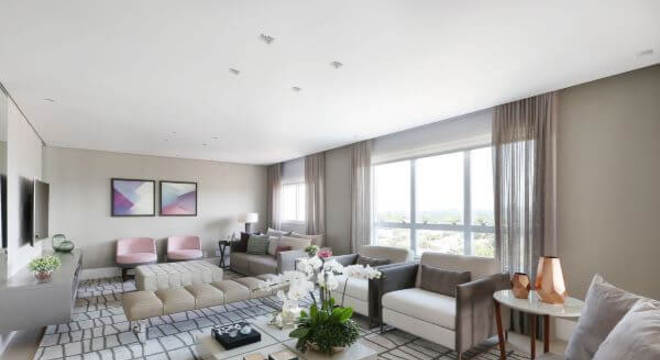 Decoração de sala de estar com tapete claro e poltronas de cores neutras