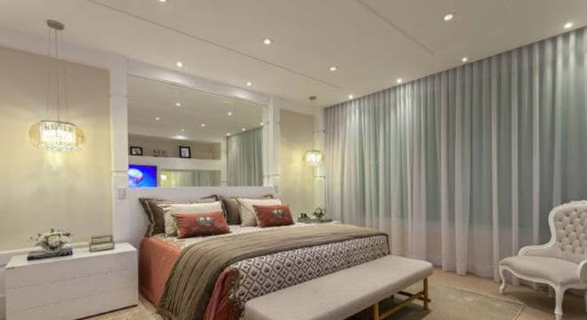 Decoração em cores neutras com espelho na cabeceira 