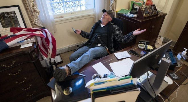 Depois de sentar na mesa da presidente da Câmara dos EUA, Nancy Pelosi, um manifestante deixou uma mensagem dizendo 'não vamos recuar'
