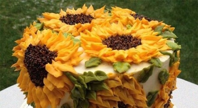 Diversas flores foram espalhadas pelo bolo para festa tema girassol