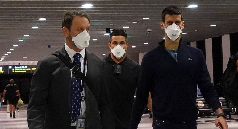 Novak Djokovic caminha no aeroporto de Melbourne antes de deixar a Austrália