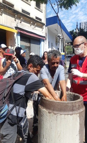 Moradores de rua precisam lavar as mãos antes de receber a marmita