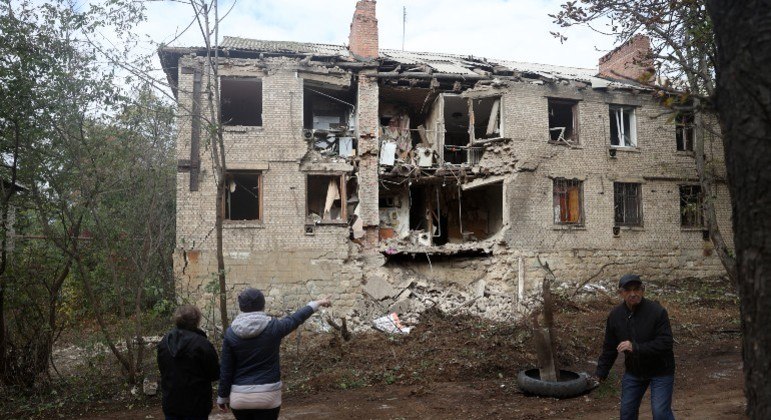 Civis observam prédio destruído por míssil na região de Donetsk
