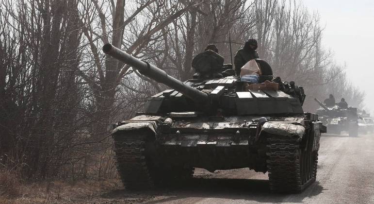 Membros do serviço de tropas pró-Rússia  são vistos no topo de um tanque na região de Donetsk