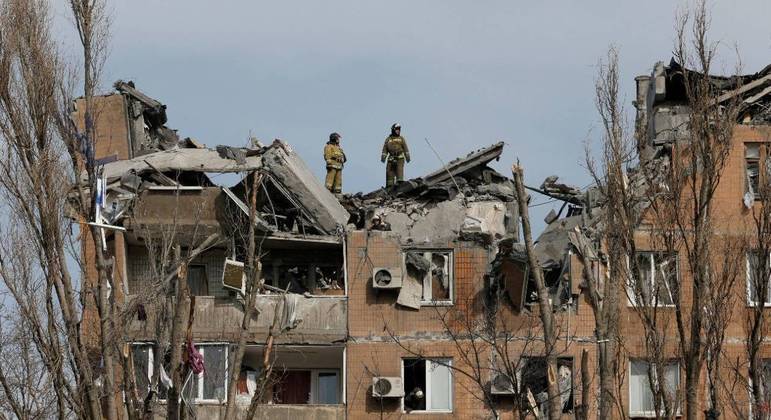 Bombeiros trabalham em um prédio residencial danificado por um bombardeio em Donetsk
