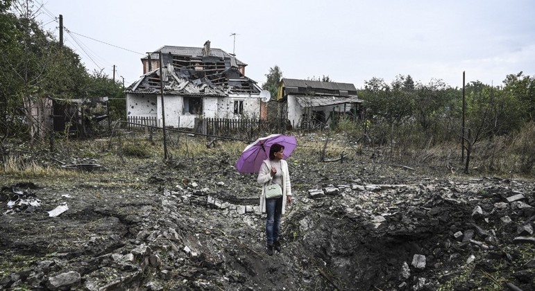 Mulher é vista em frente a uma casa destruída, em Kramatorsk, região de Donetsk