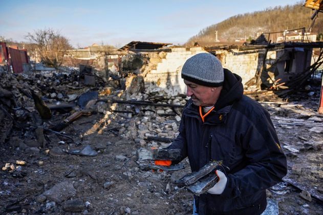 Homem caminha por entre os escombros no vilarejo de Stari Bezradychi. O local fica próximo à capital, Kiev