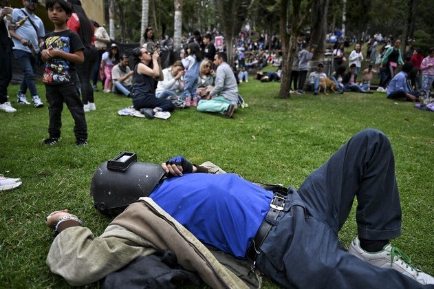 Em Bogotá, capital da Colômbia, um espectador usa uma máscara de soldador para observar o eclipse
