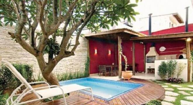 Edicula com churrasqueira e parede vermelha