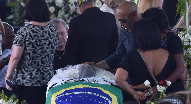 Edinho faz carinho no corpo de Pelé; caixão ganha as bandeiras do Santos e do Brasil

