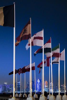 Agora, a imagem mostra as bandeiras dos países participantes da Copa do Mundo com o skyline de Doha ao fundo