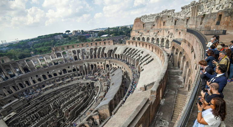 Vários turistas fotografam o interior do Coliseu desde arquibancadas restauradas em 2017