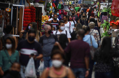 Pessoas com máscaras em rua de comércio popular no Rio