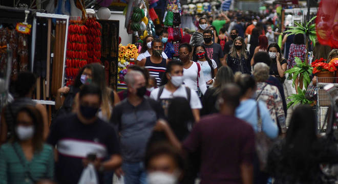 De máscara, populares caminham pelo centro do Rio
