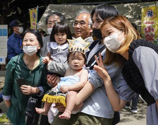 A tradição é tão forte no Japão que famílias inteiras acompanham de perto os torneio. Nesta foto, um bebê é rodeado de parentes para registrar o momento em foto