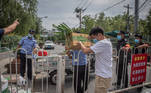 Beijing (China), 17/06/2020.- A man passes boxes of food to the security guards and policemen to be delivered to the residents living in locked-down areas in Fengtai district, near Xinfadi market, in Beijing, China, 17 June 2020. One of Beijing's largest markets, Xinfadi in Fengtai district, was shut down on 13 June, and 11 communities near the market placed under lock down following the confirmation of new domestic coronavirus cases which were linked to the Xinfadi market. Beijing has given Covid-19 nucleic acid tests to 356,000 people since 13 June, according to the city's government officials, as the number of new coronavirus cases is continuing to increase. EFE/EPA/ROMAN PILIPEY