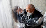 AME309. SAO PAULO (BRASIL), 02/07/2020.- María Paula Moraes abraza hoy su padre Wanderley de 82 años, que vive en una residencia de ancianos en la ciudad de Sao Paulo (Brasil), a través de una "cortina de abrazos", una alternativa válida para amenizar las medidas de distanciamiento social, durante el avance de la pandemia del coronavirus en Brasil. Pasaron más de cien días desde que María Paula Moraes abrazó por última vez a su padre, que vive en un residencia de ancianos en la ciudad brasileña de Sao Paulo. Hoy, pese al avance de la pandemia del coronavirus en Brasil, pudieron acercarse de nuevo a través de una "cortina de abrazos". EFE/Sebastião Moreira