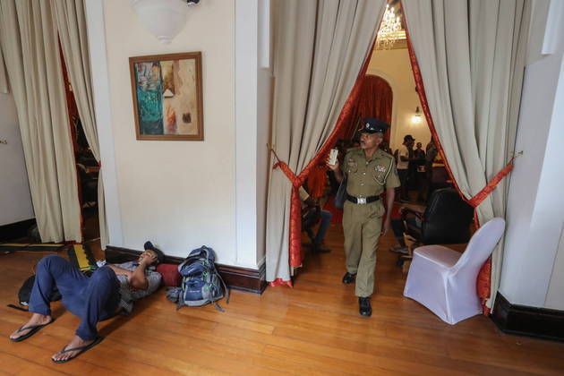 A polícia também aderiu à manifestação, como mostra essa imagem de um oficial registrando em fotos a invasão do palácio do presidente