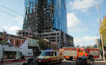 Equipes de emergência socorrem feridos perto de um prédio atingido pelos mísseis russos. Explosões foram reportadas de diversos locais da capital Kiev, com bombeiros atuando em várias situações para atender a população civil, de acordo com as autoridades ucranianas
