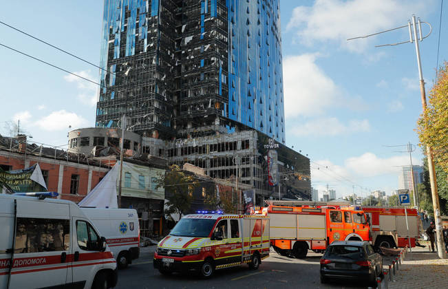 Equipes de emergência socorrem feridos perto de um prédio atingido pelos mísseis russos nesta segunda-feira (10). Explosões foram reportadas de diversos locais da capital Kiev, com bombeiros atuando em várias situações para atender a população civil, de acordo com as autoridades ucranianas