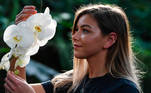 Una joven posa con un ramo de orquídeas en Londres. EFE/ Neil Hall

