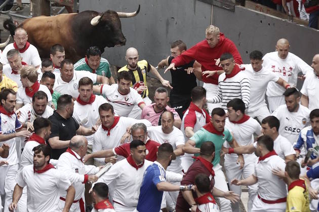 Homens provocam touros, são perseguidos, deitam no chão em posição