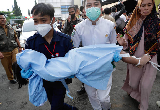 Cianjur (Indonesia), 21/11/2022.- Rescuers carries the body of a girl, victim of the earthquake that hit Cianjur, Indonesia, 21 November 2022. An earthquake with a 5.6 magnitude that hit the southwest of Cianjur District, West Java Province killed at least 20 people and hundreds were injured. (Terremoto/sismo) EFE/EPA/ADI WEDA