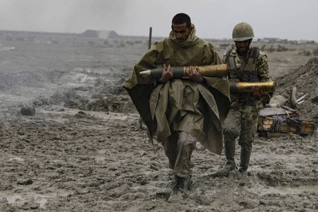 Nesta imagem, soldados iranianos carregam bombas para serem colocadas em canhões