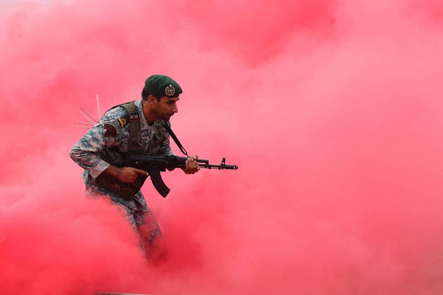 A poucas horas de 2023, o Exército do Irã pratica um exercício militar numa praia próxima ao Estreito de Ormuz desde a última sexta-feira (30). Na foto, um soldado invade um território hostil depois de uma bomba de dispersão com gás vermelho ser atirada e provocar o efeito surpresa