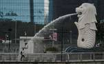 Singapore (Singapore), 22/01/2021.- A man holding an umbrella walks past the Merlion statue in Singapore, 22 January 2021. Singapore's economy is expected to rebound four to six per cent in 2021 following its worst recession due to the economic fallout caused by the Covid-19 coronavirus pandemic (Singapur, Singapur) EFE/EPA/WALLACE WOON