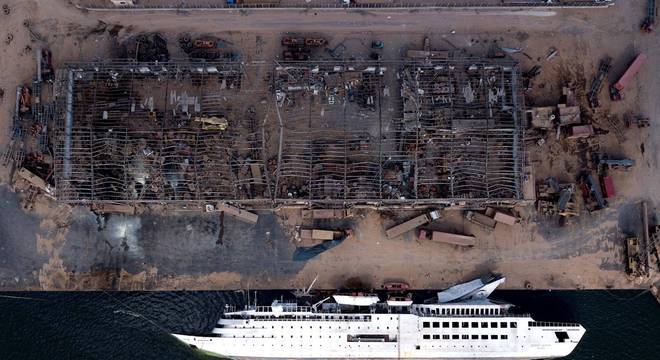 Imagem aérea do porto de Beirute após explosão: navio virado e prédio destruído