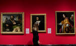 London (United Kingdom), 03/12/2020.- A gallery employee poses for photographers next to a painting entitled "A portrait of Jacopo Sannazaro" (C) by Italian master Titian during a photocall "Masterpieces from Buckingham Palace" at The Queen'Äôs Gallery in London, Britain, 03 December 2020. Masterpieces from Buckingham Palace at The Queen'Äôs Gallery will open to the public on 04 December. The exhibition brings together 65 of the most treasured paintings and includes works by Titian, Rembrandt, Rubens, Vermeer, Van Dyck and Canaletto am others. (Reino Unido, Londres) EFE/EPA/FACUNDO ARRIZABALAGA