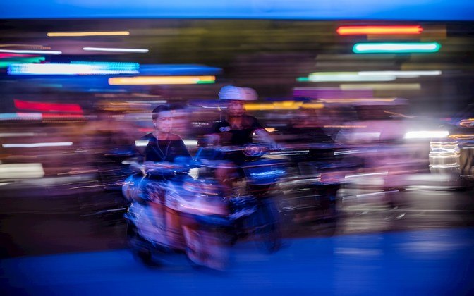 Suhanghai (China), 23/07/2021.- A long exposure photo shows people ride motorcycles on a street in Shanghai, China, 23 July 2021. After the typhoon Cempaka hit South China on 20 July and the heavy rain in Central China causing flooding on 21 July, Shanghai Metrological Centre issues a typhoon warning as typhoon In-Fa approaching China'Äôs east coast. Rainfall in Shanghai is expected from Saturday to Monday. (Inundaciones) EFE/EPA/ALEX PLAVEVSKI