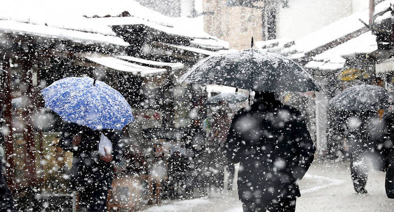 Sarajevo (Bosnia And Herzegovina), 15/03/2021.- People walk under a heavy snowfall on a street in Sarajevo, Bosnia and Herzegovina, 15 March 2021. Meteorologists forecast snowy weather with low temperatures to continue in the upcoming days. (Bosnia-Herzegovina) EFE/EPA/FEHIM DEMIR