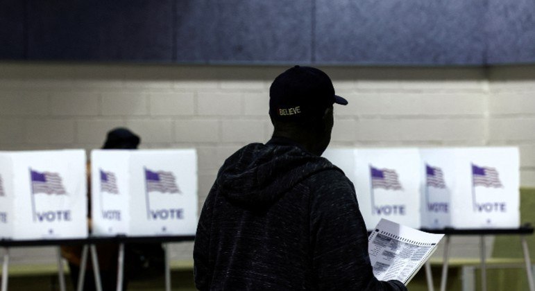 Homem espera para entrar em cabine de votação em Detroit, Michigan