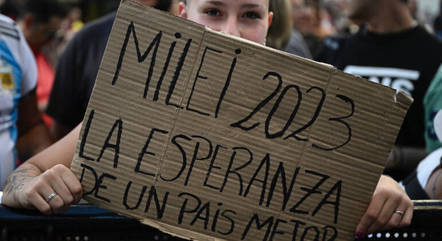 Eleitora de Milei mostra cartaz em apoio ao candidato à Presidência da Argentina