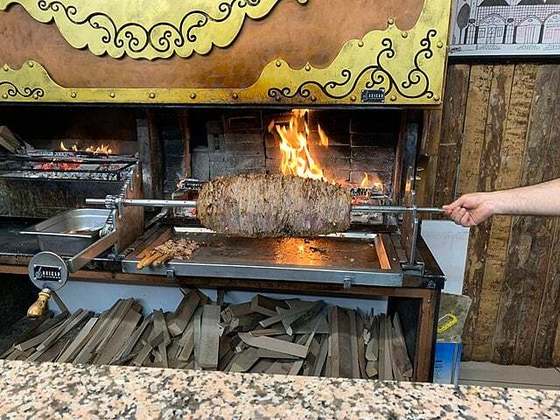 Em seguida, o cordeiro é cortado em fatias e vai para um espeto menor. As pessoas têm a opção de comer o kebab nesse espeto ou enrolado no pão pita que acabou de ficar pronto e deve ser ingerido ainda quente. 