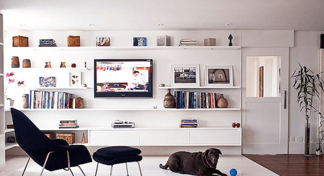 Em um ambiente pequeno deixe o sofá de lado e invista em poltronas para sala de tv com descanso para os pés