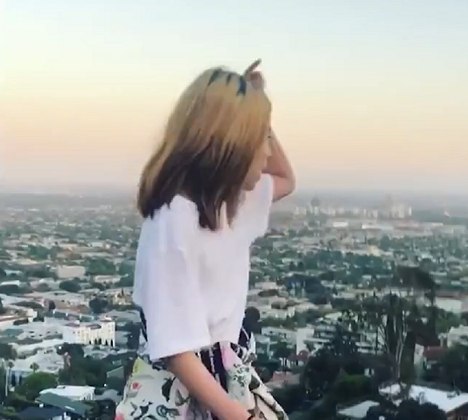 Em um dos clipes, Lil Tay surge no topo de um mirante de Beverly Hills, na Califórnia, e grita: “Eu comando Los Angeles.”