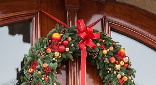 Enfeite de natal para porta feito com ramos e pinhas