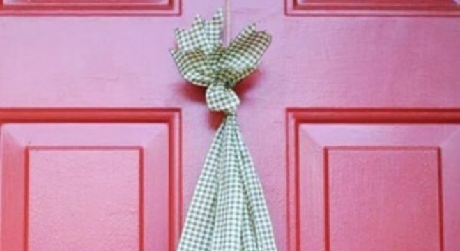 Enfeite de natal para porta feito com tecido e pinhas