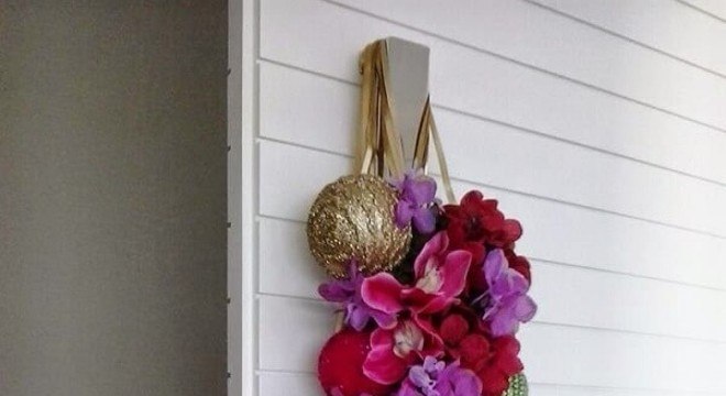 Enfeite de porta para natal feito com flores e posicionado na maçaneta