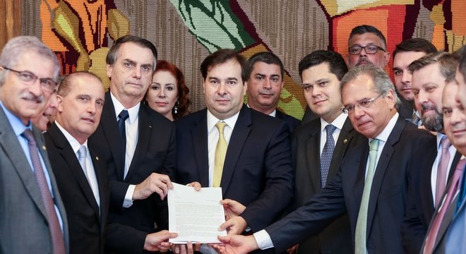 Entre outros membros do Executivo e do Legislativo, o presidente Jair Bolsonaro, o presidente da Câmara, Rodrigo Maia, e o ministro da Economia, Paulo Guedes, mostram primeiro documento com proposta da reforma