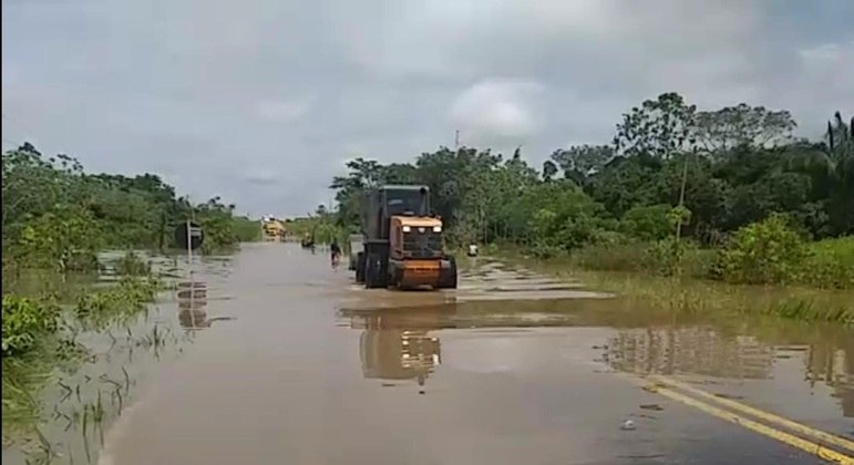 Escavadeira foi utilizada para transportar os malotes de prova pela estrada alagada
