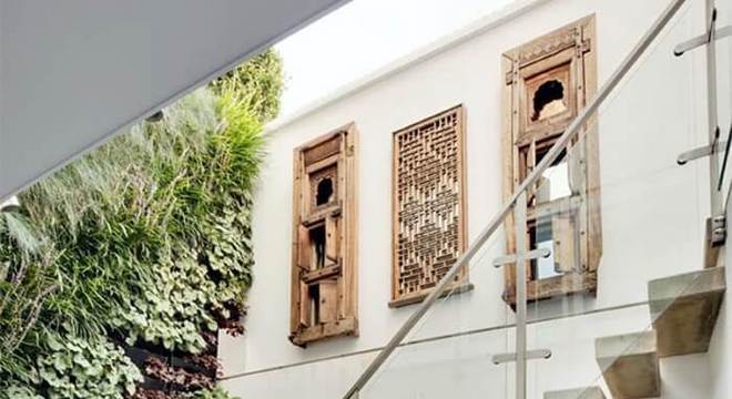 Escada flutuante de concreto e parede com jardim vertical