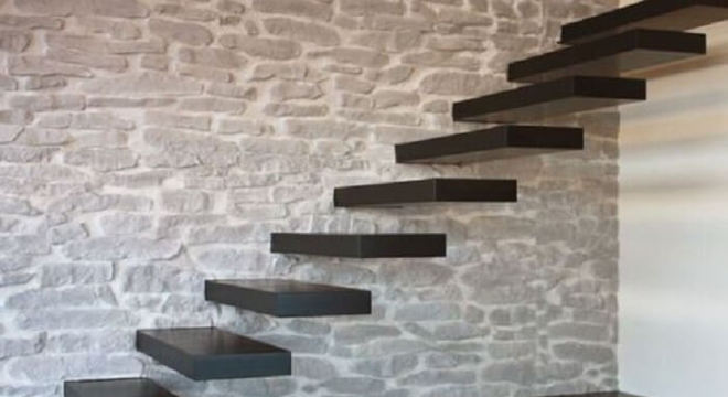 Escada flutuante de madeira fixada em parede de pedras